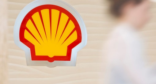 Shell sign with employee climbing steps in the background