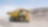 Yellow dumper truck driving through gravel