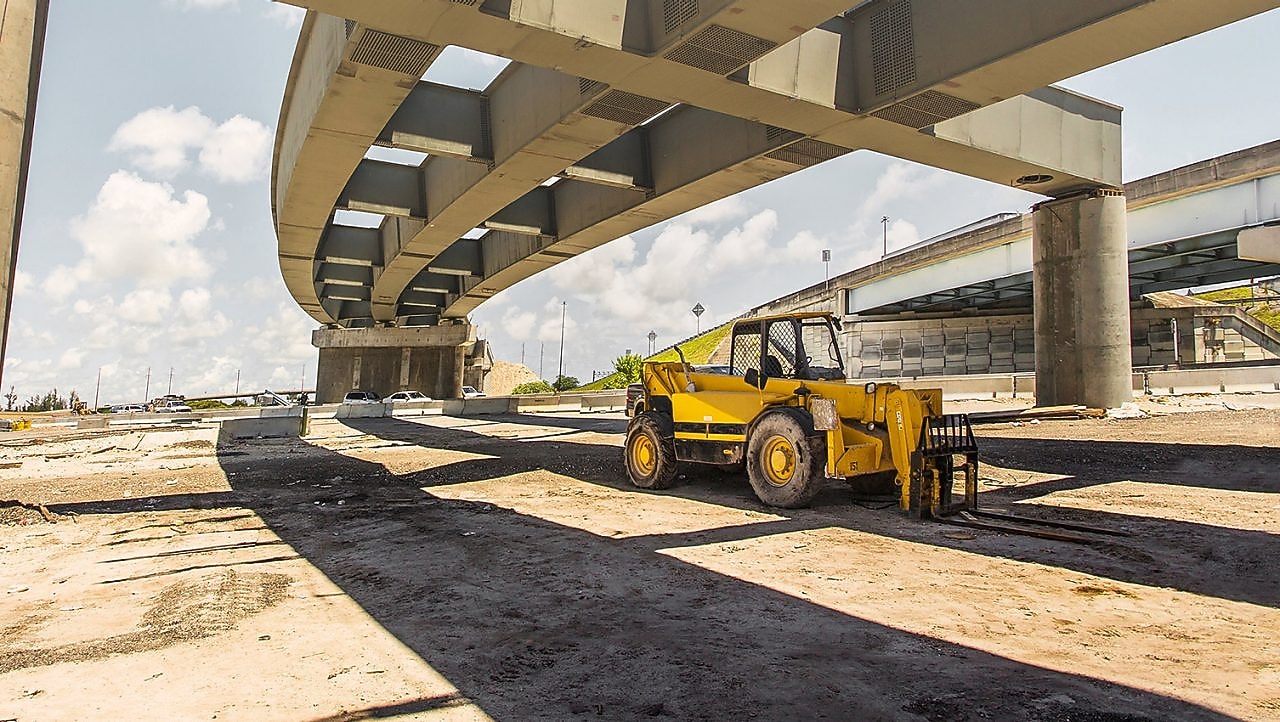 A yellow truck driving down a road at dusk
