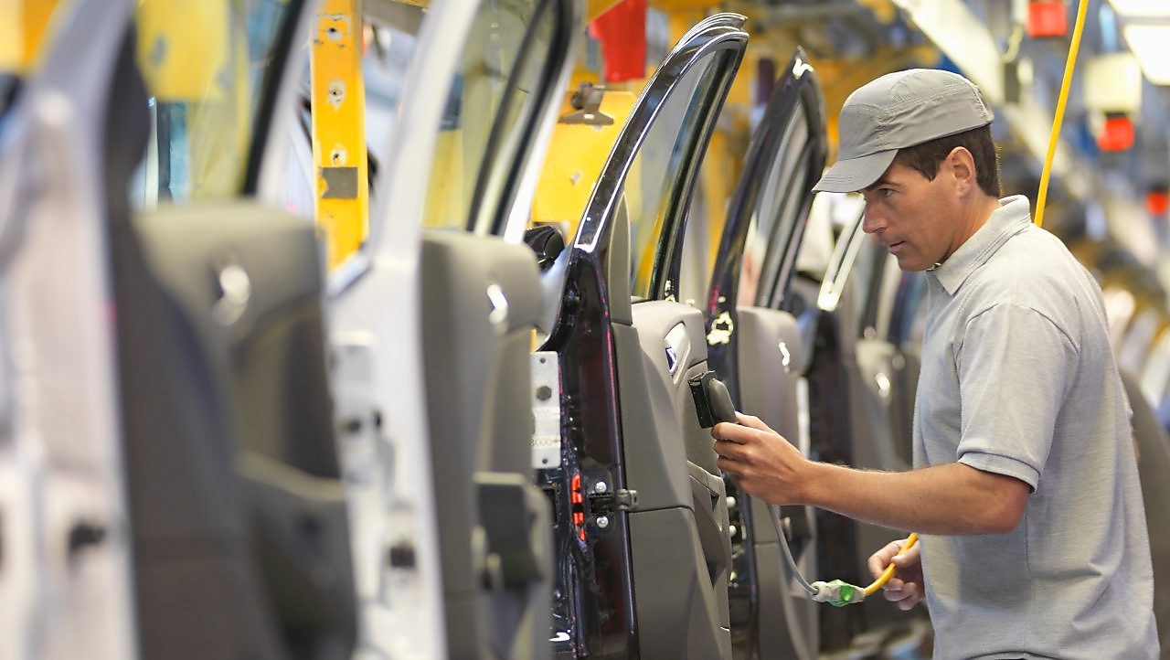 Man holding wire looking at machine