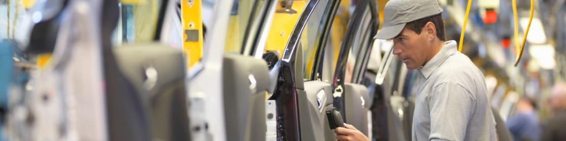man holding wire looking at machine