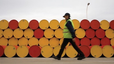 man walking barrels lubricants