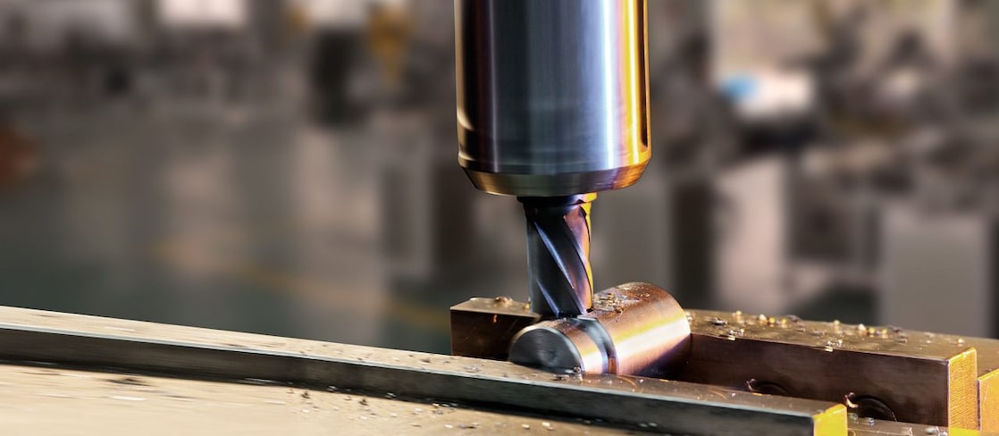 A drill bit drilling into some metal