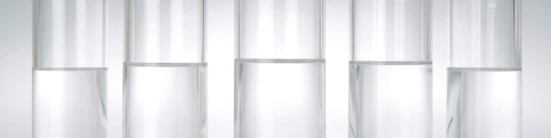 Five beakers in a row with a clear liquid in each one