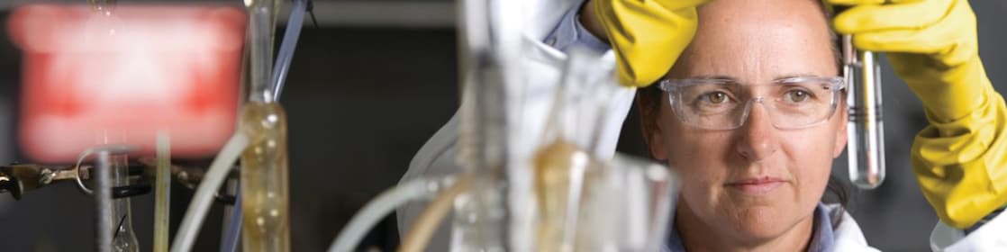 lady in safety goggles conducting a lab experiment