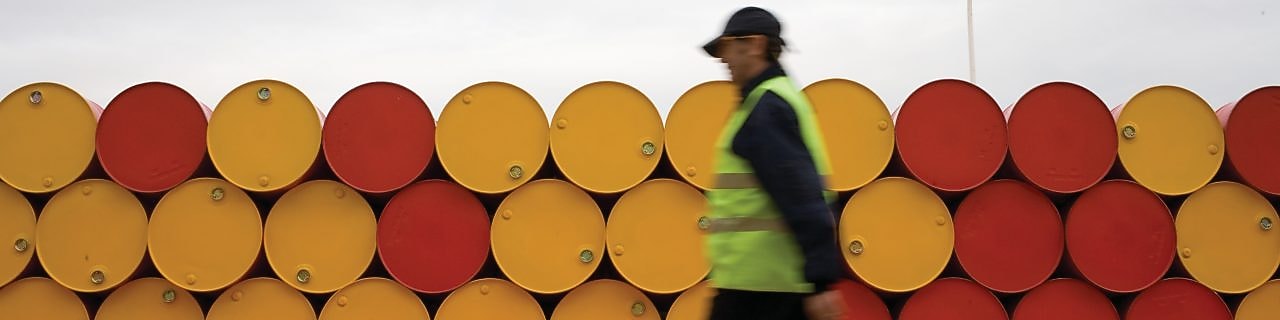 man walking barrels lubricants