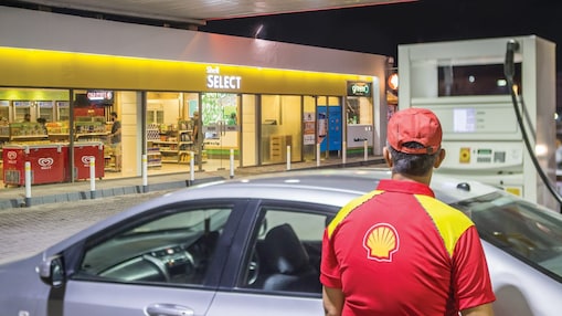 Sun rising behind a Shell station forecourt