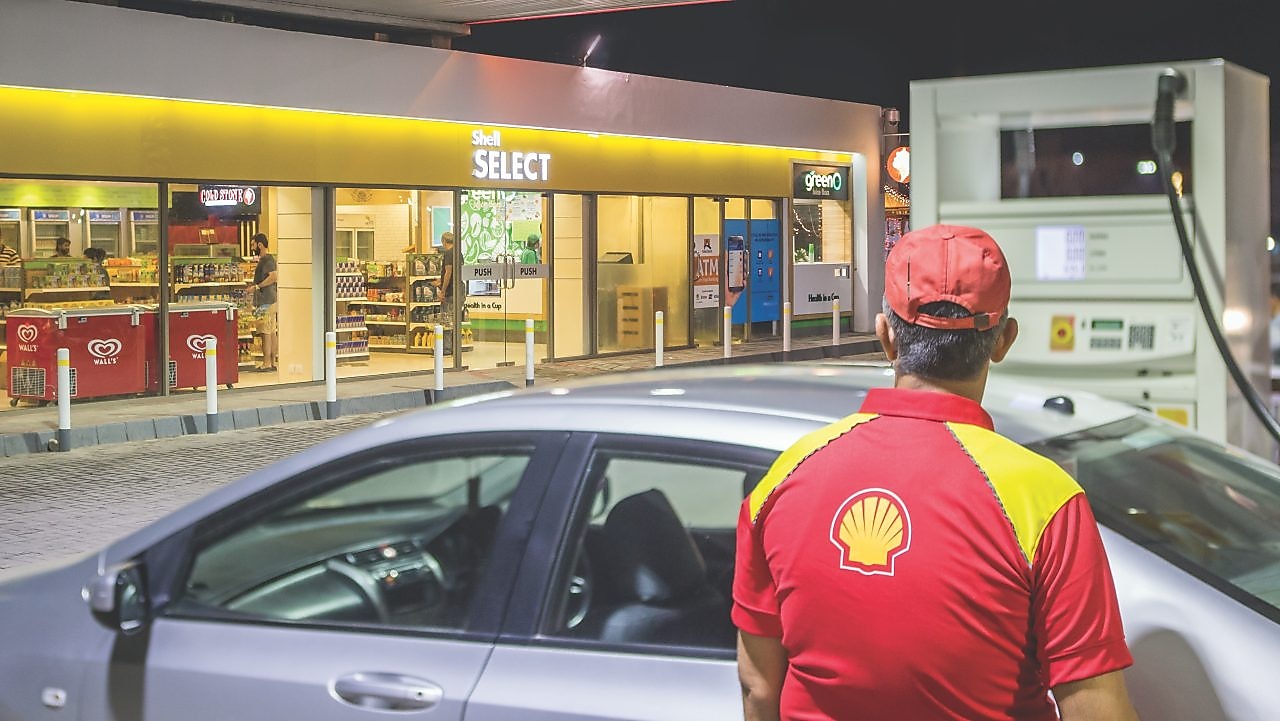 Sun rising behind a Shell station forecourt