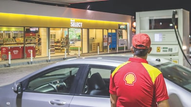 Sun rising behind a Shell station forecourt