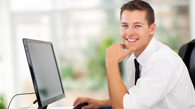 Man working on computer and smiling